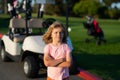 Kid in golf park near golf cart. Child summer vacation. Lifestyle portrait of funny kid outdoors. Summer kids outdoor Royalty Free Stock Photo