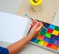 Kid hand brush and plain paper with square color palette  for art work,top view Royalty Free Stock Photo