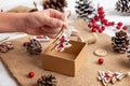 Kid hand drop a small decorative Christmas tree into the gift box Royalty Free Stock Photo