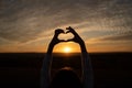 Kid hand heart shape silhouette made against the sun sky of a sunrise or sunset Royalty Free Stock Photo