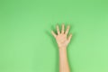 Kid hand palm or showing five fingers on green background Royalty Free Stock Photo