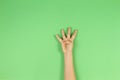 Kid hand showing four fingers on green background Royalty Free Stock Photo