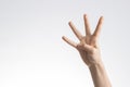 Kid hand showing and pointing up with fingers number four on white wall background Royalty Free Stock Photo