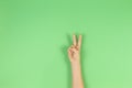 Kid hand with two fingers up on green background. Number two, peace or victory symbol Royalty Free Stock Photo