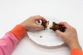 Kid hands breaking chocolate flavored crispy rice wafer snacks on white background