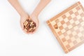 Top view of kid hands with chess pieces and chess board on white background Royalty Free Stock Photo