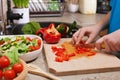 Kid hands chopping red bellpepper for a delicious vegetable salad