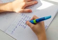 Kid hands doing math homework. Close up of young boy hand holding pen and writing a math homework close-up. concept of education Royalty Free Stock Photo