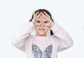 Kid with hands glasses in front of her eyes isolated on white background. Little asian girl looking through imaginary binocular