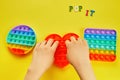 Kid hands playing with colorful pop It fidget toy. Colorful antistress sensory toy fidget push pop it. Royalty Free Stock Photo