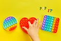 Kid hands playing with colorful pop It fidget toy. Colorful antistress sensory toy fidget push pop it. Royalty Free Stock Photo