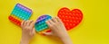 Kid hands playing with colorful pop It fidget toy. Colorful antistress sensory toy fidget push pop it. Royalty Free Stock Photo