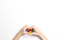 Kid hands in the shape of heart and colorful heart made of plastic construction puzzle pieces on white background. World Royalty Free Stock Photo