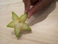 Star fruit closeup holds by fingers