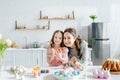 Kid and happy mother near painted chicken eggs, decorative rabbits, easter bread and tulips Royalty Free Stock Photo