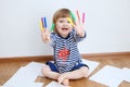 Kid happy smiling sitting on floor playing with felt tip pens. baby girl painting and playing. colorful stuff felt pen caps Royalty Free Stock Photo