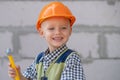 Kid in hard hat holding hammer. Happy smiling little child helping with toy tools on construciton site. Kids with Royalty Free Stock Photo