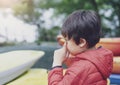 Kid having allergy, itchy and rubbing eyes while playing by the lake, little boy scratching nose, Children has reflection or hay Royalty Free Stock Photo