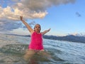 Kid having fun at the beach. Happy child girl in pink swinsuit playing in the sea. Summer vacation, travel and active lifestyle Royalty Free Stock Photo