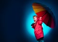 Kid having fun with Leaf fall. Raining kids. Cheerful boy in raincoat with colorful umbrella. Funny face. Cloud rain