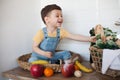 Kid having a table full of organic food. Cheerful toddler eating healthy salad and fruits. Baby choosing between apples, bananas,