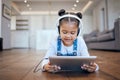 Kid, headphone and tablet for streaming in home with internet for entertainment, learning or watching. Little girl Royalty Free Stock Photo