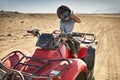 Kid in helmet and protect mask riding quad bike