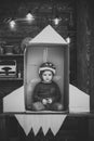 Kid in helmet sit in cardboard hand made rocket. Child boy play cosmonaut, astronaut. Childhood concept. Boy play at