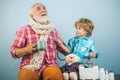 Kid helps senior man to take his pills. Man in knitted colorful scarf with medicine. Little doctor ready to examine.