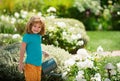 Kid helps to care for the plants in the garden. Little boy with a watering can on backyard. Concept of plant growing Royalty Free Stock Photo