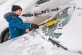 Kid helps to clear the car of snow