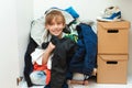 Mess in the wardrobe. Boy with messy colorful clothing at room. Untidy clutter clothing closet