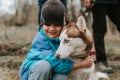 kid and his friend husky siberian dog. portrait little child boy hugging cute white brown mammal animal pet Royalty Free Stock Photo