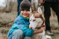 kid and his friend husky siberian dog. portrait little child boy hugging cute white brown mammal animal pet Royalty Free Stock Photo