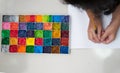 Kid hold brush and plain paper with square color palette for art work