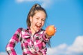Kid hold ripe apple sunny day. Kid girl with long hair eat apple blue sky background. Healthy nutrition concept. Child Royalty Free Stock Photo