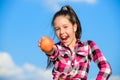 Kid hold ripe apple sunny day. Kid girl with long hair eat apple blue sky background. Healthy nutrition concept. Child Royalty Free Stock Photo