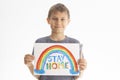 Kid holding drawing picture with rainbow with words Stay at home. Social media campaign for coronavirus prevention