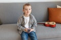 Kid holding TV remote controller. Boy without parental control watching television