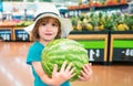 Kid holding watermelon in supermarket. Vegetables in store. Royalty Free Stock Photo