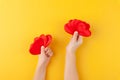 Kid holds in hands red hearts, children arms, love and valentines day concept, horizontal, yellow background