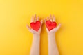 Kid holds in hands red hearts, children arms, love and valentines day concept, horizontal, yellow background