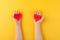 Kid holds in hands red hearts, children arms, love and valentines day concept, horizontal, yellow background