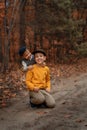 The kid hugs his older brother. Children in retro clothes in the forest. Family values.