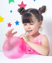 Kid inflates a big bubble from slime.