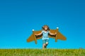 Kid with jet pack superhero. Child pilot against summer sky background. Boy with paper plane flight, toy airplane with Royalty Free Stock Photo