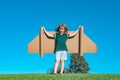 Kid with jet pack superhero. Child pilot against summer sky background. Boy with paper plane flight, toy airplane with Royalty Free Stock Photo