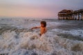 Kid jumping near the waves. Happy kid have fun in sea on beach. Travel lifestyle, swimming activities summer camp.