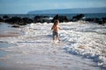 Kid Jumping in Sea Ocean Waves. Jump by Water splashes. Summer day, ocean coast, Beach. Active kids lifestyle and Royalty Free Stock Photo