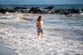 Kid Jumping in Sea Ocean Waves. Jump by Water splashes. Summer day, ocean coast, Beach. Active kids lifestyle and Royalty Free Stock Photo